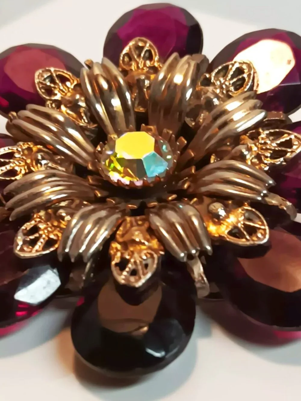 Vintage ruby lucite brooch with aurora borealis central rhinestone.